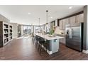 Open concept kitchen with stainless steel appliances, island with seating, and hardwood floors that flow into the living area at 600 Hedrick Ridge Road # 306, Cary, NC 27519