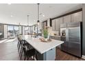 Modern kitchen with stainless steel appliances, gray cabinets, white countertops and island with bar stool seating at 600 Hedrick Ridge Road # 306, Cary, NC 27519