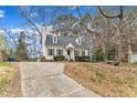 A cozy house with dormer windows set on a slight hill is surrounded by trees and a front yard at 6100 River Laurel Ct, Raleigh, NC 27604