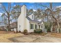 Charming two-story home featuring a tall chimney, green shutters, dormer windows, and a front yard at 6100 River Laurel Ct, Raleigh, NC 27604