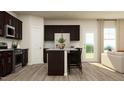 Modern kitchen featuring stainless steel appliances, dark cabinets, a central island with seating, and access to the living area at 620 Vega Bluff Ln, Angier, NC 27501
