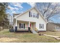 Charming two-story home featuring a welcoming front porch and a freshly painted red front door at 636 Tucker St, Burlington, NC 27215