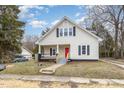 Charming two-story home featuring a welcoming front porch and a freshly painted red front door at 636 Tucker St, Burlington, NC 27215