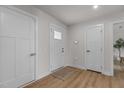 Bright and airy foyer with multiple white doors, wood-look flooring, and neutral walls at 82 Coble Farms Pl, Fuquay Varina, NC 27526
