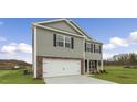 Charming two-story home featuring a stone facade, attached garage, and a spacious lawn at 871 Forth Ct, Gibsonville, NC 27249