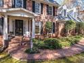 Elegant brick entryway with a white columned porch and lush landscaping around the front door at 10005 Avocado Cir, Raleigh, NC 27615