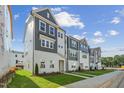 Row of new townhomes featuring gray and white accents, sidewalks and freshly installed lawns at 1035 Zelkova Ln, Chapel Hill, NC 27517