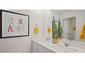 Bathroom with double sink vanity, decorative mirror, and cheerful artwork at 106 Craig Point Dr, Clayton, NC 27520