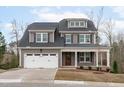Charming two-story home with a well-manicured lawn, a two-car garage, and inviting front porch at 116 Pointe Park Cir, Holly Springs, NC 27540