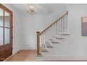 Bright foyer staircase features hardwood treads, white risers, and a wooden handrail for a classic design at 116 Pointe Park Cir, Holly Springs, NC 27540
