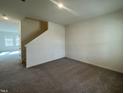 The room has carpet and leads to a staircase, offering a view of the home's interior at 128 Oat Grain Ct, Clayton, NC 27520