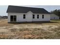 Rear exterior view showcasing windows and siding, providing ample natural light, with an expansive backyard at 164 Jones Creek Ln, Lillington, NC 27546