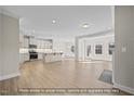 Open-concept living room and kitchen featuring hardwood floors, stainless steel appliances, and modern lighting at 1811 Parham Dr, Graham, NC 27253