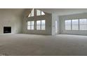 Open concept living room with high ceilings, fireplace, and large windows at 187 Dairymont Dr, Pittsboro, NC 27312
