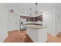 Modern kitchen with stainless steel appliances, granite countertops, wood floors, and island with breakfast bar at 222 Glenwood Ave # 608, Raleigh, NC 27603