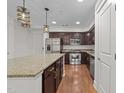 Open kitchen featuring stainless steel appliances, dark cabinets, granite countertops, and island with pendant lighting at 222 Glenwood Ave # 608, Raleigh, NC 27603