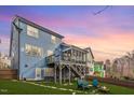 Back of house with large yard, seating area and screened in porch at 2245 Dunlin Ln, Raleigh, NC 27614