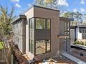 Angle view of a modern home featuring a brick and gray wood facade and large windows at 2305 Turners Aly, Raleigh, NC 27607