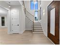 Bright foyer with a staircase, large windows, wood flooring, and a stylish front door creating a welcoming entrance at 2305 Turners Aly, Raleigh, NC 27607