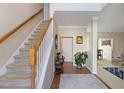 Inviting foyer featuring a staircase with wooden handrail, hardwood floors and elegant decor at 2321 Bolingbrook Ln, Raleigh, NC 27613