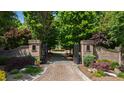 View of the property entrance featuring brick pillars, an iron gate, and a landscaped driveway at 2421 Acanthus Dr, Wake Forest, NC 27587