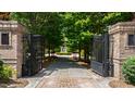 View of the property entrance featuring brick pillars, an iron gate, and a landscaped driveway at 2421 Acanthus Dr, Wake Forest, NC 27587