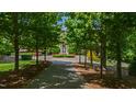 Stately brick home featuring a circular driveway with fountain and manicured landscaping through trees at 2421 Acanthus Dr, Wake Forest, NC 27587