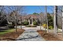 Majestic brick home with lush landscaping and a circular driveway, nestled among mature trees at 2421 Acanthus Dr, Wake Forest, NC 27587