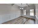 Bright dining room boasts coffered ceilings, wood floors, and elegant wainscoting at 257 Swann Trl, Clayton, NC 27527