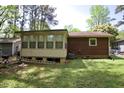 The back of the house features a cozy enclosed porch and a well-maintained lawn, perfect for outdoor activities at 2726 Thelma St, Durham, NC 27704