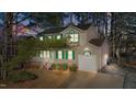 Charming home at dusk featuring green shutters, a front porch, a well-kept lawn, and an attached one-car garage at 300 Pate St, Apex, NC 27502