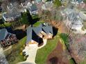 Aerial view of a brick house in a wooded neighborhood with manicured lawn at 3109 Doe Hill Ct, Raleigh, NC 27612