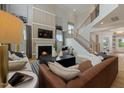 Cozy living room featuring a fireplace, a large sofa, and an open staircase at 353 Belmont Stakes Ln, Wendell, NC 27591