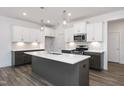 Beautiful kitchen with stainless appliances, white cabinets and grey island with sink at 3933 Willow Gate Way, Knightdale, NC 27604