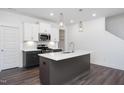 Bright kitchen with center island, stainless appliances and stylish pendant lighting at 3933 Willow Gate Way, Knightdale, NC 27604