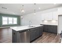 Spacious kitchen features a center island with a sink, stainless steel appliances and stylish lighting at 3933 Willow Gate Way, Knightdale, NC 27604