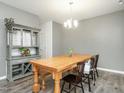Dining room with wood-look floors, a large wooden table, and a gray hutch for storage at 516 Spaulding St, Burlington, NC 27215
