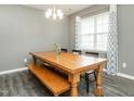 Dining room features a large wooden table, wood-look floors, modern chandelier, and a sunlit window at 516 Spaulding St, Burlington, NC 27215