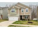 Two-story home with neutral siding and a two-car garage is surrounded by a well-maintained yard at 516 Spaulding St, Burlington, NC 27215