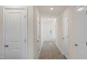 Bright hallway featuring multiple doors, neutral walls, and modern flooring, offering a clean aesthetic at 521 Fife Ct, Gibsonville, NC 27249