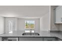 Modern kitchen featuring granite countertops, stainless sink, and scenic window view at 523 Fife Ct, Gibsonville, NC 27249