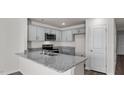 Well-equipped kitchen with sleek gray cabinetry, granite counters, and stainless appliances at 523 Fife Ct, Gibsonville, NC 27249