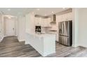 Beautiful kitchen with white cabinets, stainless appliances, a kitchen island and hardwood flooring at 624 Emerald Bay Cir, Raleigh, NC 27610
