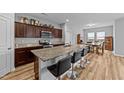 Open-concept kitchen featuring granite countertops, stainless steel appliances, and bar stool seating at 629 Kenyon Spring Dr, Zebulon, NC 27597