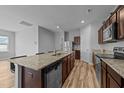 Modern kitchen boasts an island with sink, granite countertops, and stainless-steel appliances at 629 Kenyon Spring Dr, Zebulon, NC 27597