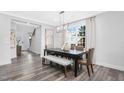 Dining room with hardwood floors, a modern chandelier, and access to the kitchen and living areas at 637 Emerald Bay Cir, Raleigh, NC 27610