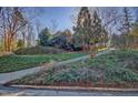 A long driveway leads up to a charming home surrounded by lush landscaping and mature trees, providing privacy at 805 Greenwood Rd, Chapel Hill, NC 27514