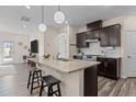 Open concept kitchen featuring a granite island with seating, stainless steel appliances, and dark cabinetry at 917 Matterhorn Dr, Fuquay Varina, NC 27526