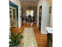 Welcoming hallway featuring hardwood floors, a decorative rug, and a view of the dining area at 917 Widewaters Pkwy, Knightdale, NC 27545