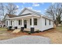 Quaint single-story home featuring a cozy front porch and refreshed landscaping at 1034 Maple St, Henderson, NC 27536
